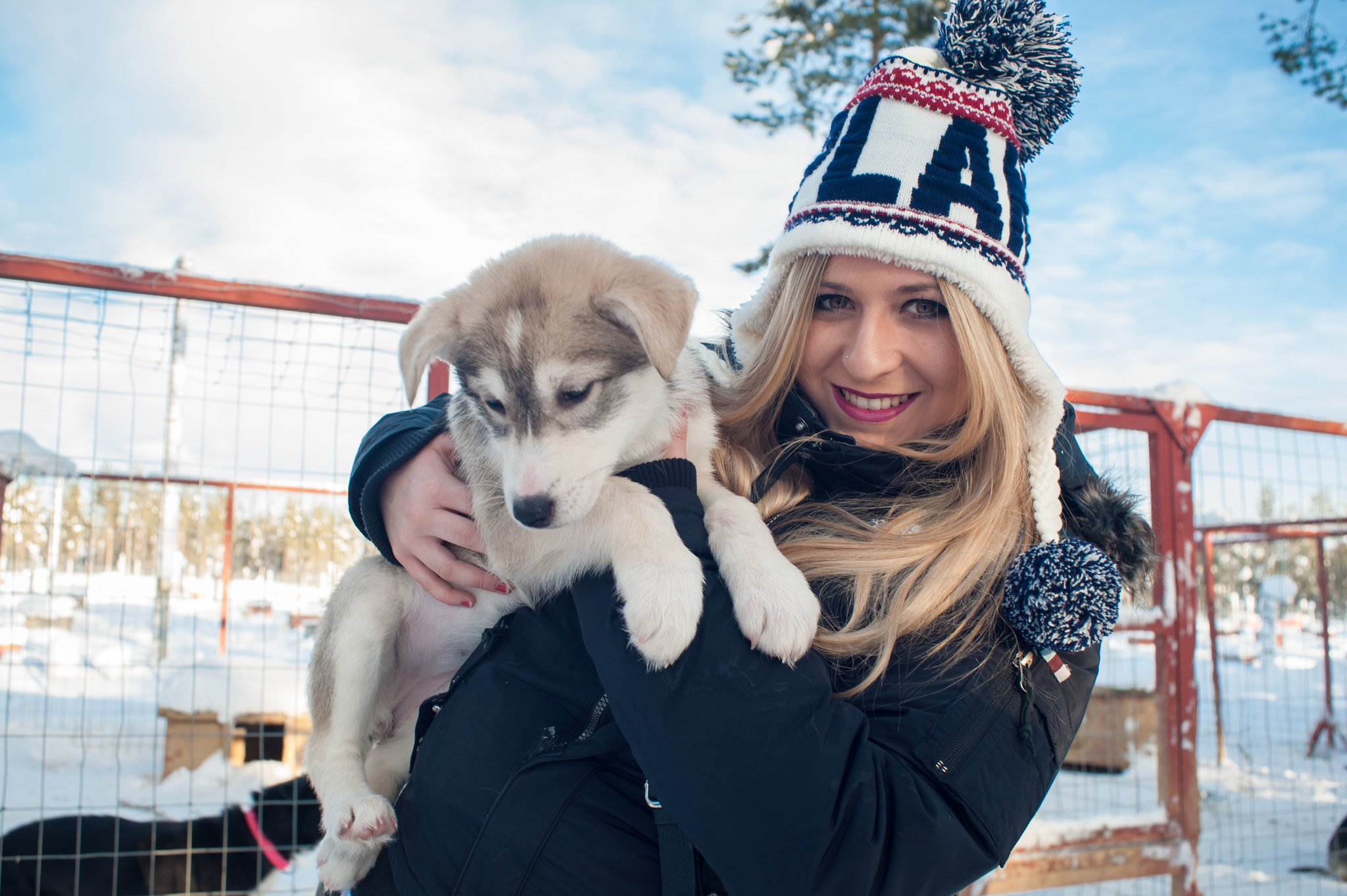 girl smiling hugging a husky puppy