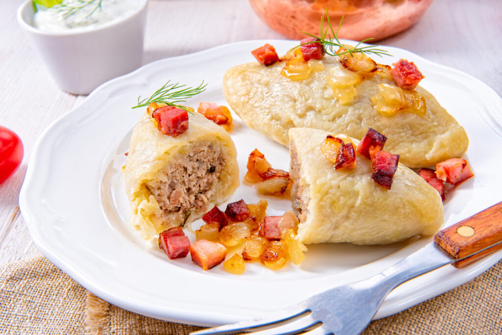 a plate of Cepelinai - Lithuanian potato dumplings