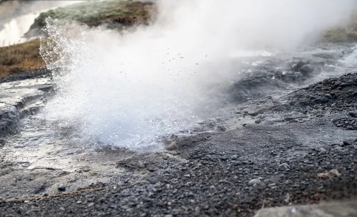 Litli Geysir erupting with white water bubbles in the air