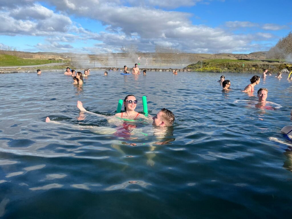 a couple floating and smiling in the lake with floating sticks